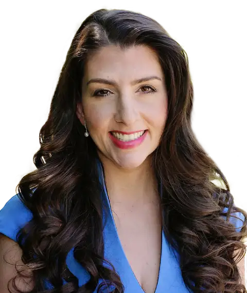 OB/GYN and fertility specialist Dr. Aimee Eyvazzadeh. Dr. Aimee is a Caucasian woman with long dark hair wearing a blue cap-sleeve dress with a v-neck.