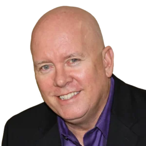 CEO of Cicero DX, Chris Jackson, a bald white man with light gray eyes, clean-shaven, wearing a purple dress shirt and a black suit jacket.