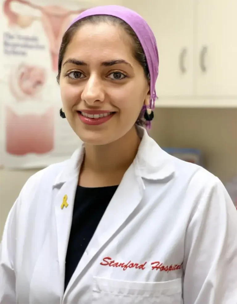 Dr. Atena Asiaii, a smiling woman with dark hair wearing a physician's white coat.