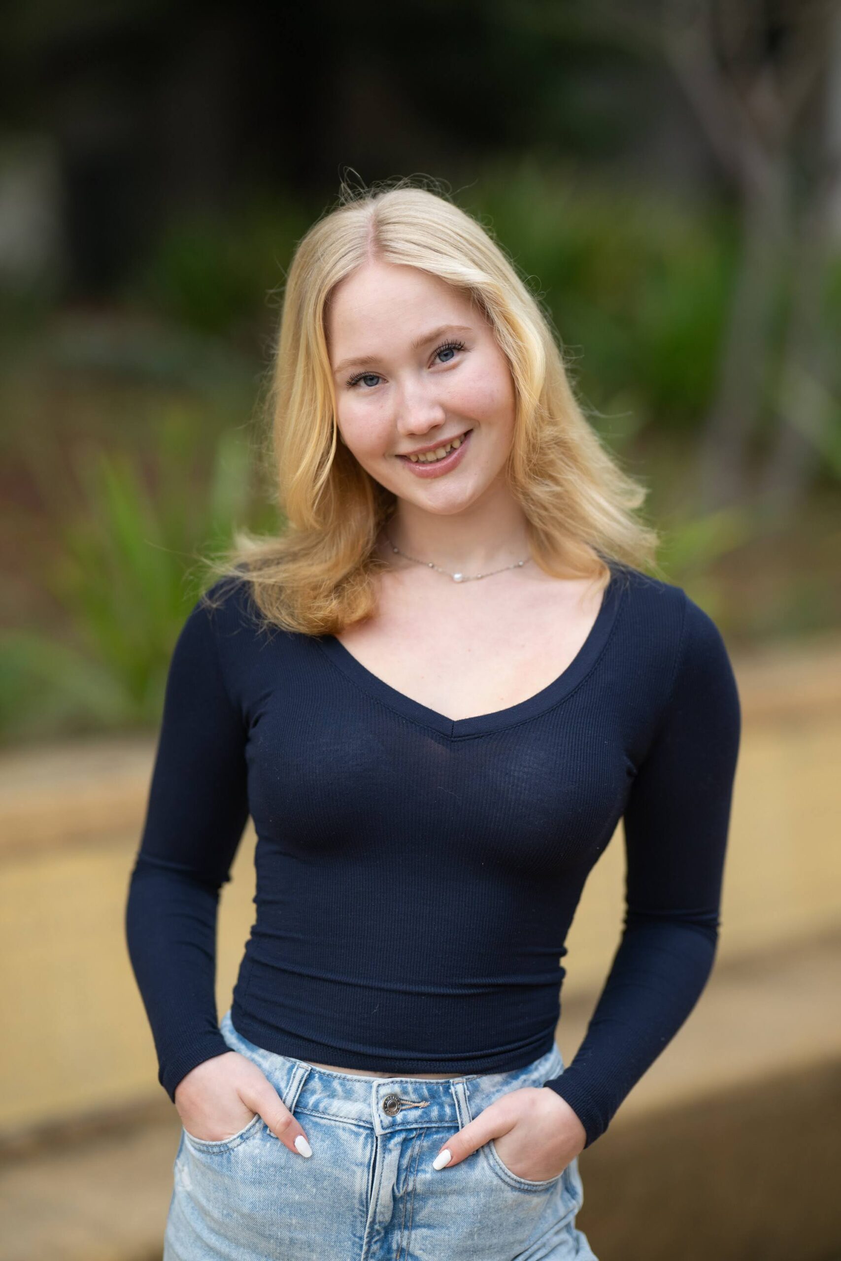 Quincy Adam smiles warmly while speaking to a group of teenage girls about endometriosis awareness, encouraging open conversations about menstrual health.